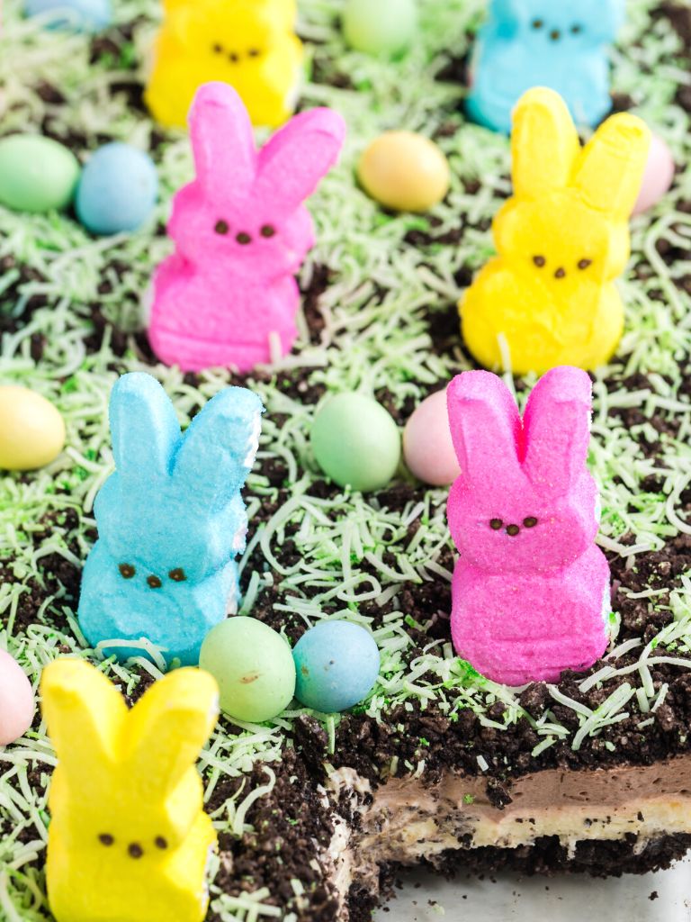 A dirt cake that is no bake with peeps on it and a piece of it cut out so you can see the layers in this picture. 