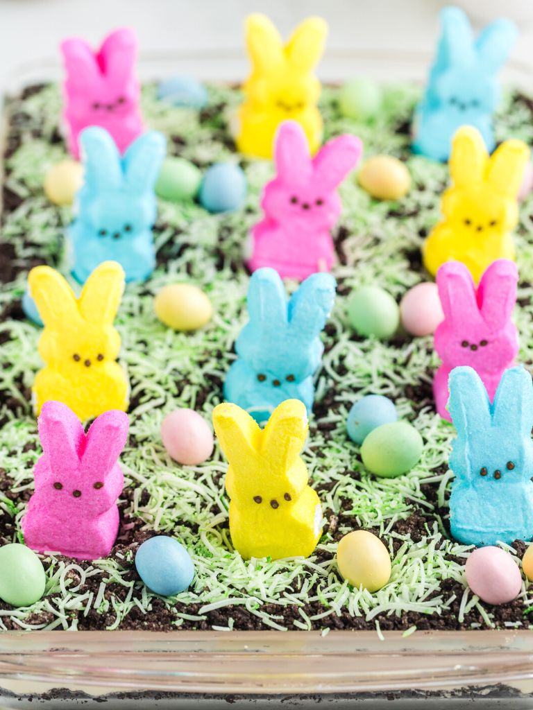 A pan of no bake easter desserts with peeps and chocolate eggs.