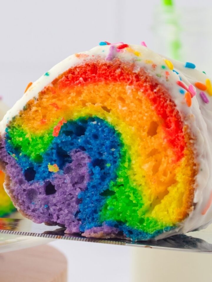 Close up of a slice of the rainbow layers inside this cake.