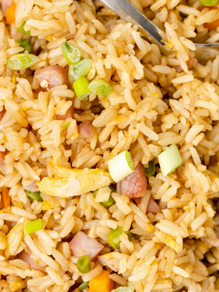 Close up of fried rice with ham and eggs in it. 