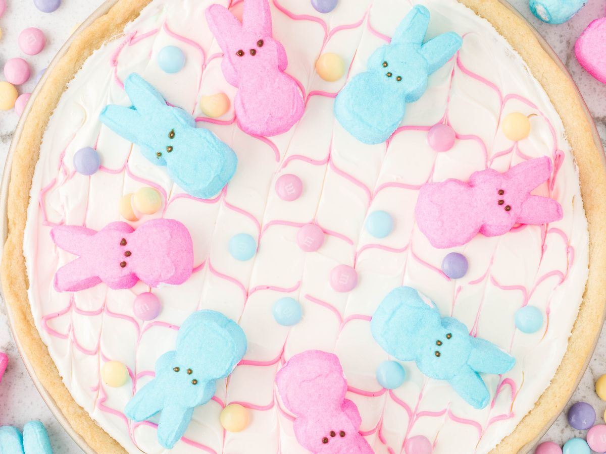 Process photos showing how to make this easter peeps cookie pizza. 