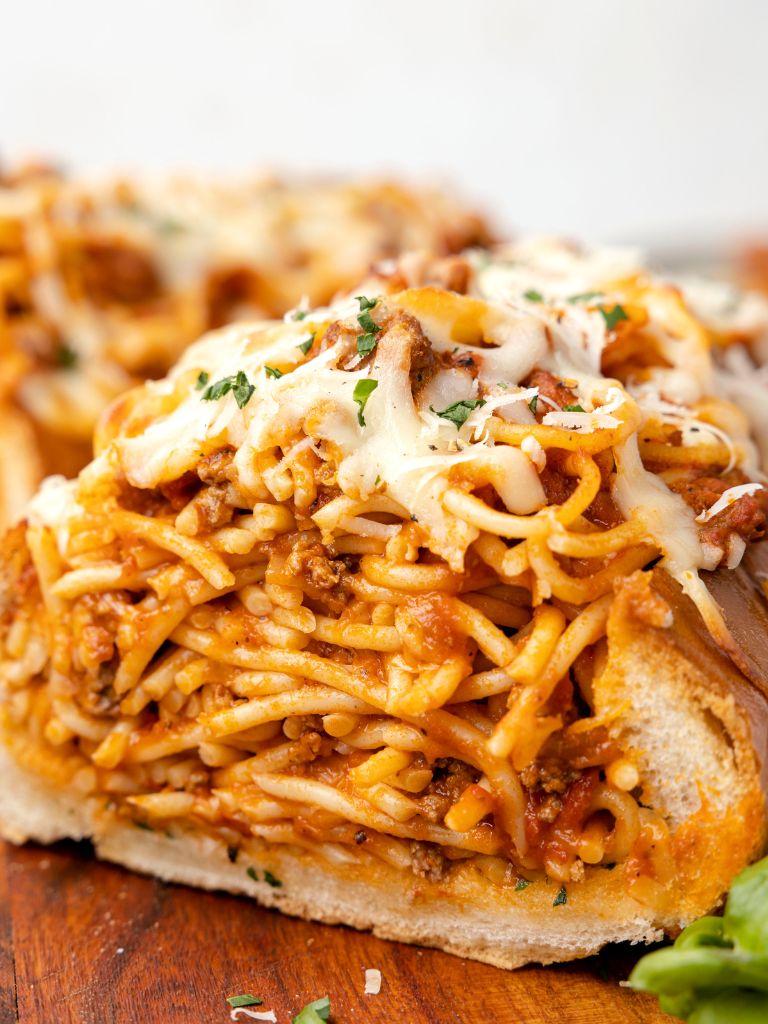 Front view of this stuffed garlic bread with spaghetti.