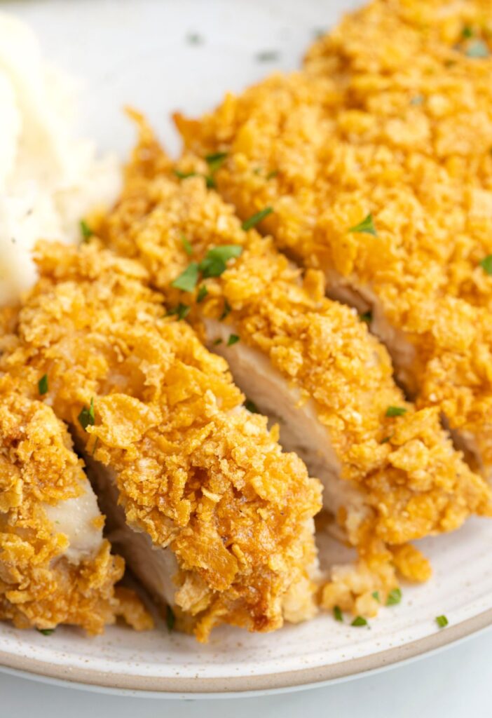 Close up picture of the sliced baked chicken with the crumb coating on it. 