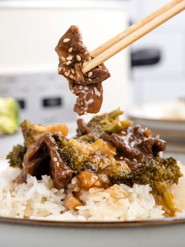 A chopstick holding some of the beef on it from the recipe. 