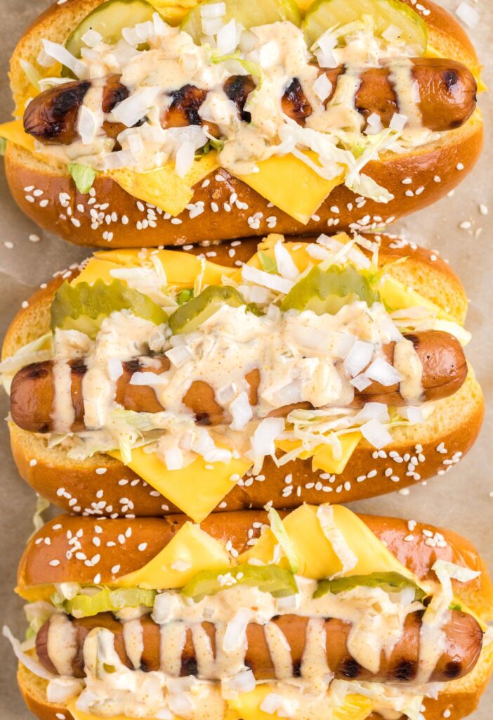 Overhead shot of the hot dogs with sauce, lettuce, and cheese.