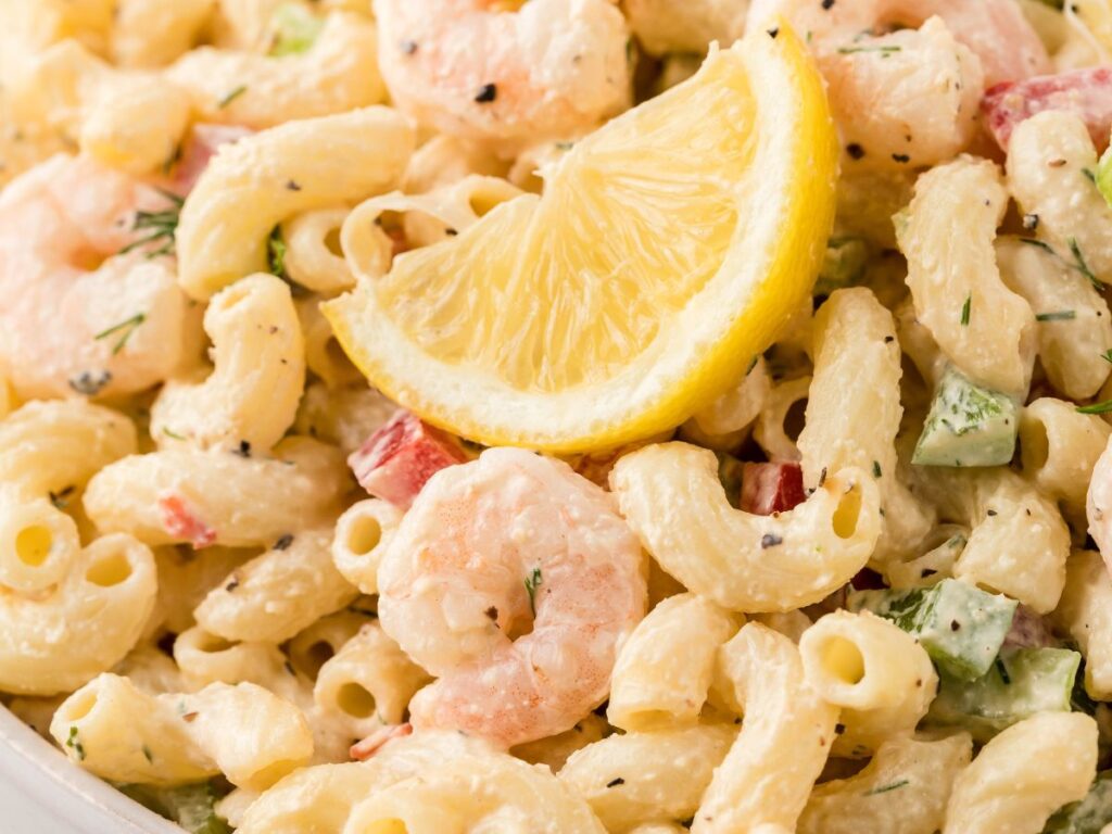 Close up of this macaroni salad with a lemon wedge in it. 
