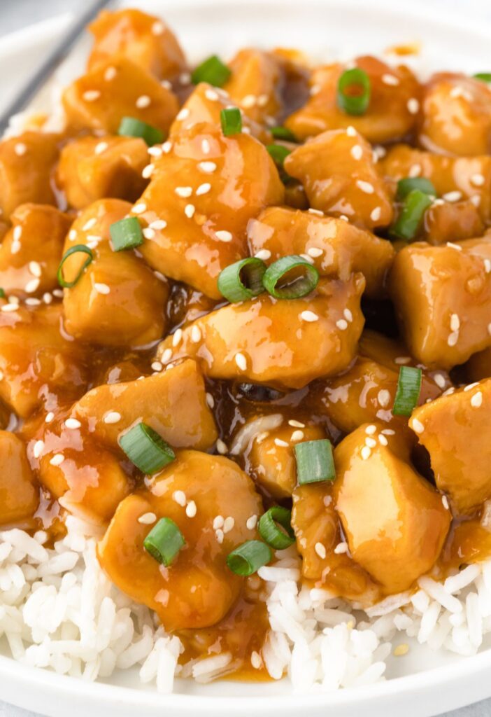 A plate of rice topped with this chicken cooked in apricot sauce. 