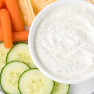 Dip inside a bowl with dippers around it like veggies and chips.
