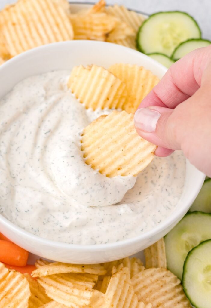 A chip scooping up some dip to show how to serve it. 