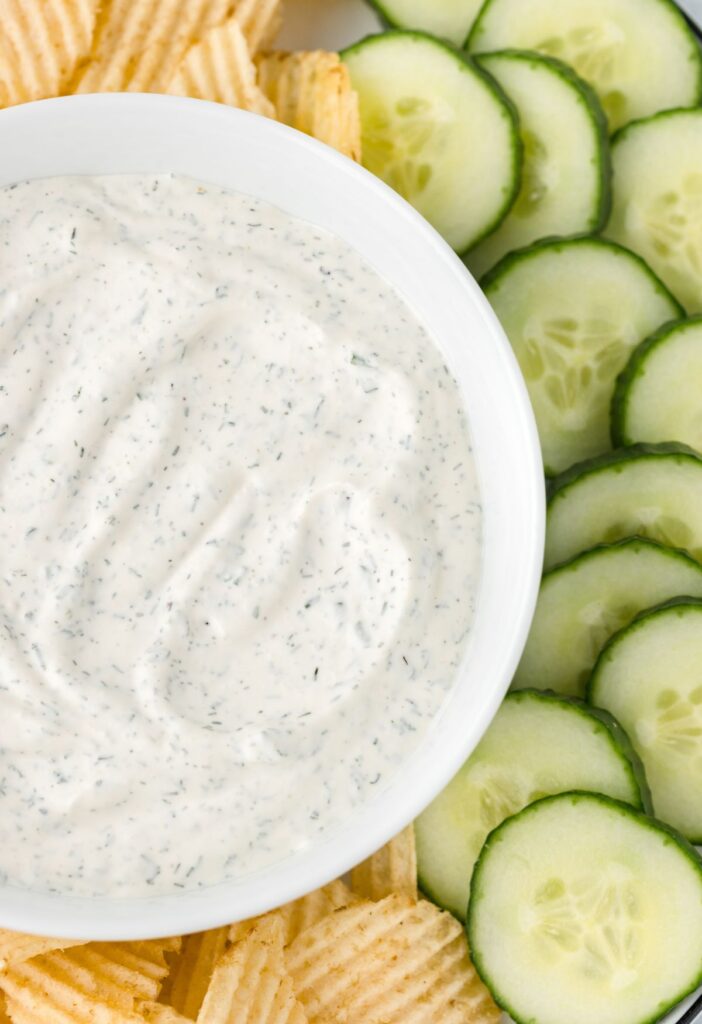 Close up of the dip by the cucumbers on the plate. 