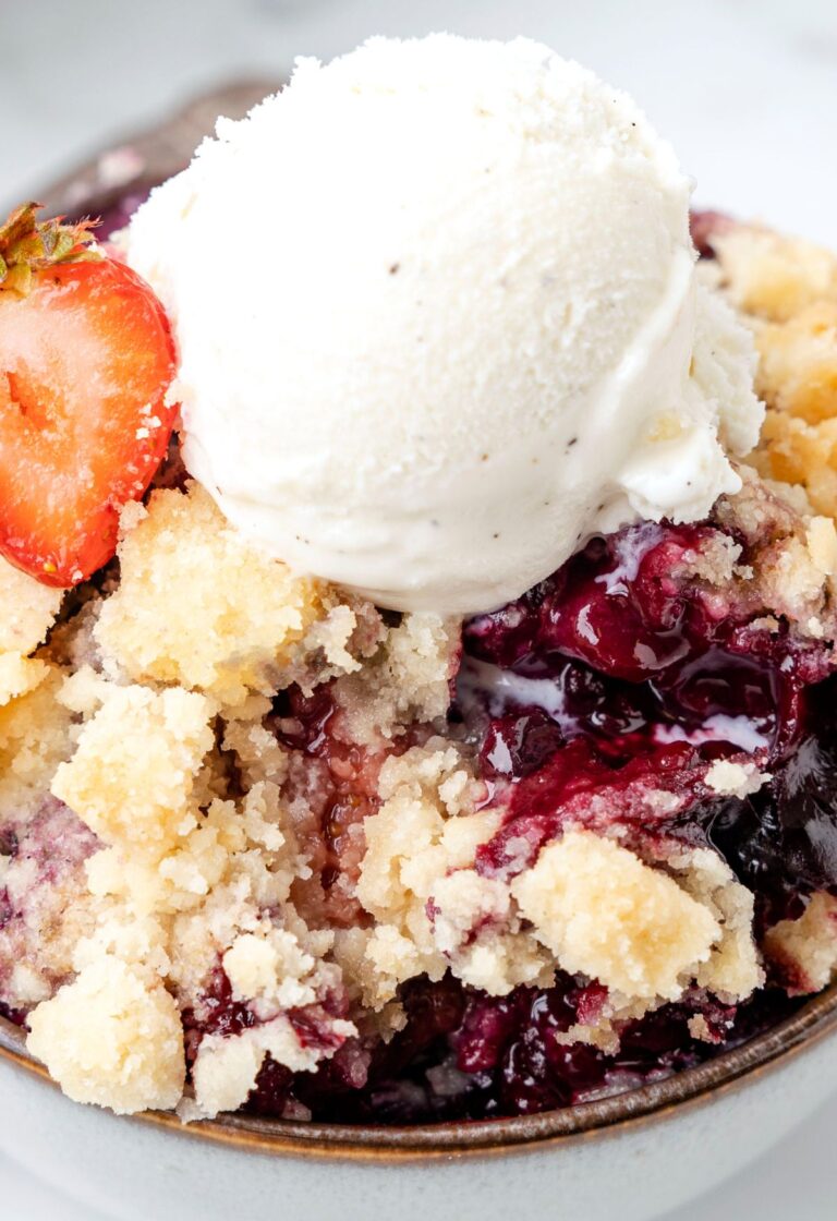 A close up of a serving of this cobbler topped with ice cream.