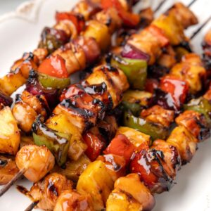 Photo of the grilled chicken kabobs with pineapple on wooden skewers.