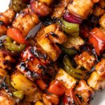 A pile of kabobs glazed with sauce.