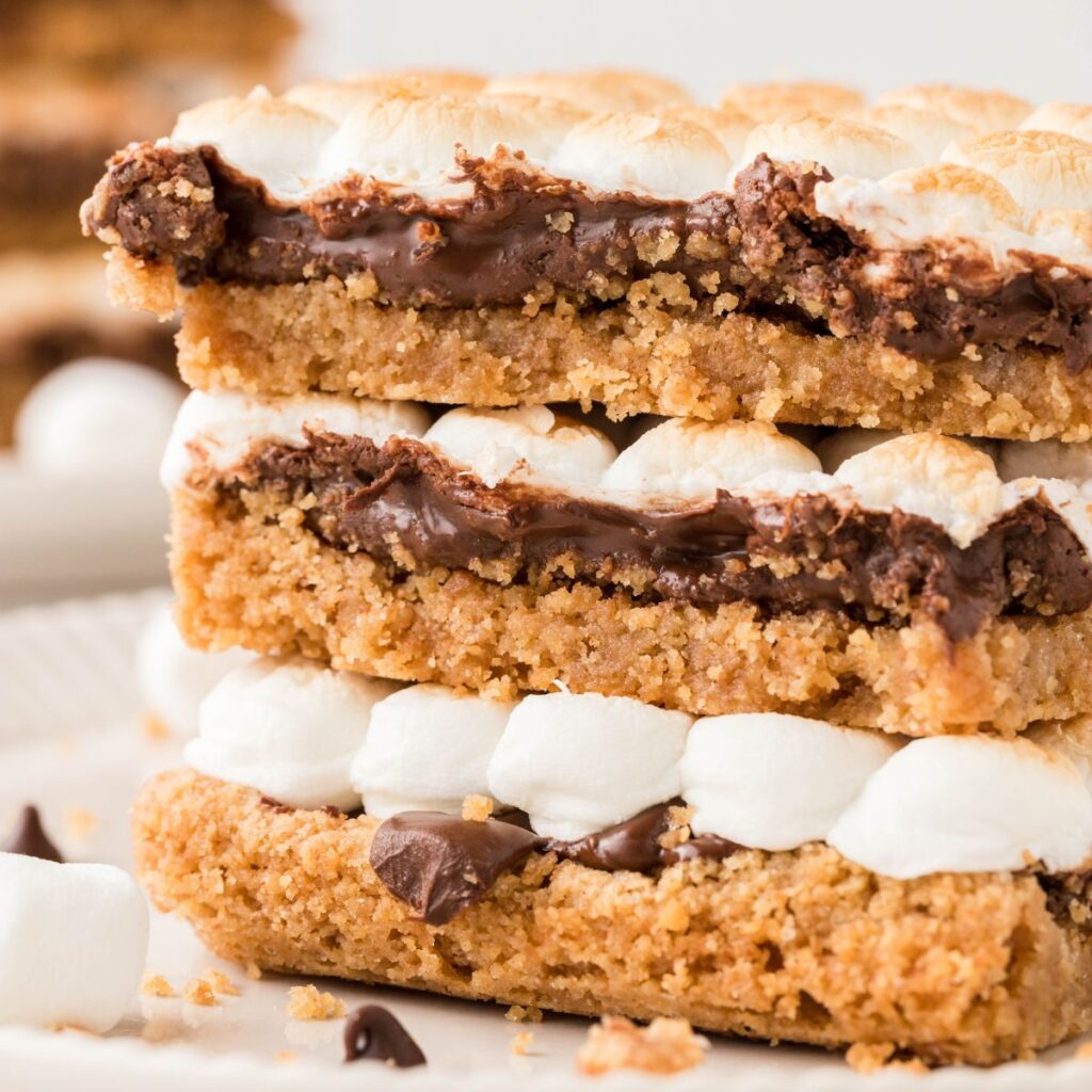 A stack of cooked smores bars on a white plate.