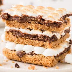 Stack of cookie bars with smores ingredients.