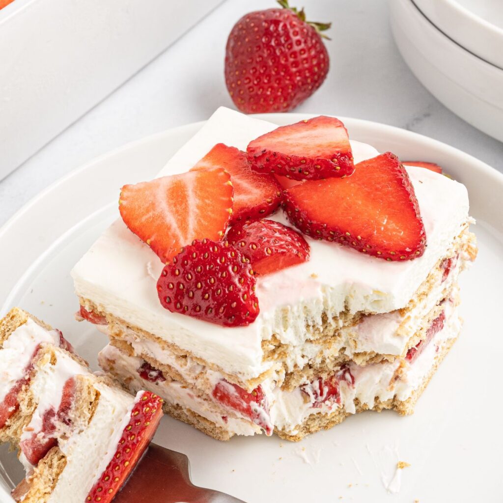 A serving of the icebox cake with a fork on a white plate. 