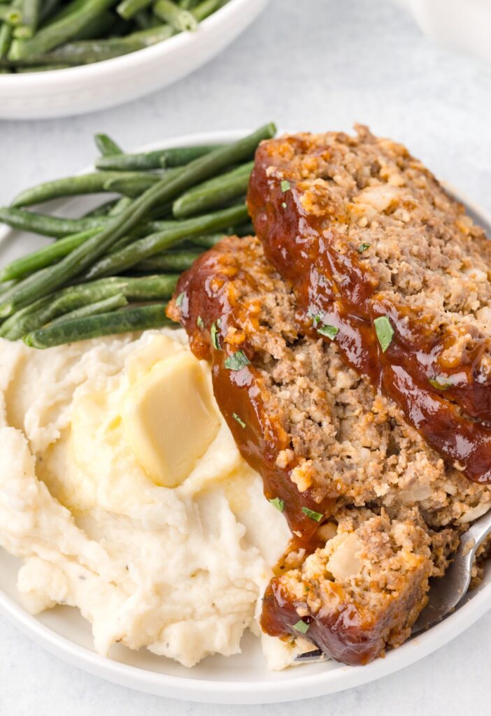 Plate of served meatloaf with sides. 