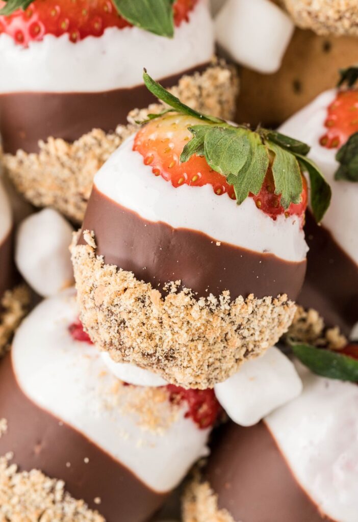 A pile of dipped strawberries in marshmallow and chocolate. 