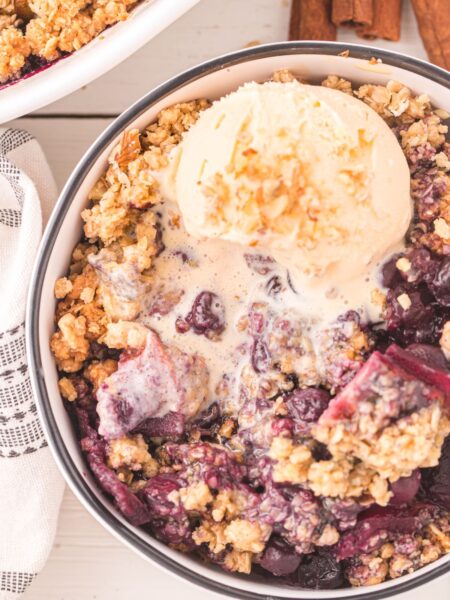 Apple Blueberry Crumble inside a bowl with ice cream.