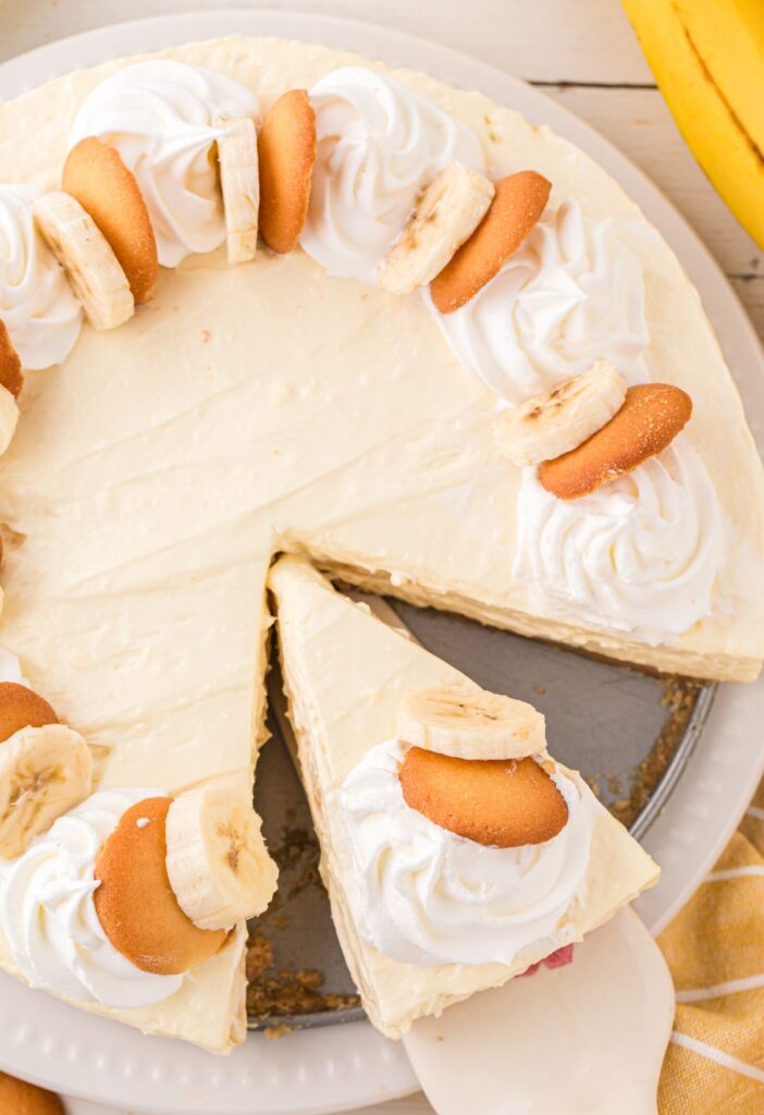 overhead shot of the cheesecake with slices cut into it and cookies on top. 