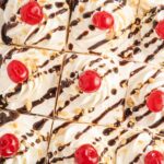 Top if the icebox cake with cherries, chocolate sauce, peanuts, and cool whip.