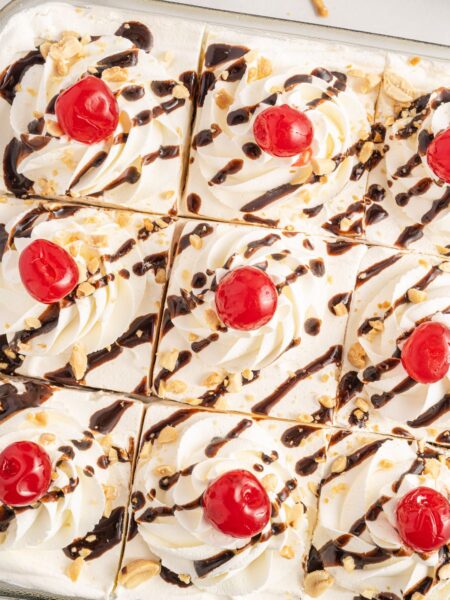 Top if the icebox cake with cherries, chocolate sauce, peanuts, and cool whip.