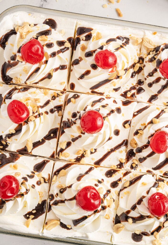 Top if the icebox cake with cherries, chocolate sauce, peanuts, and cool whip. 