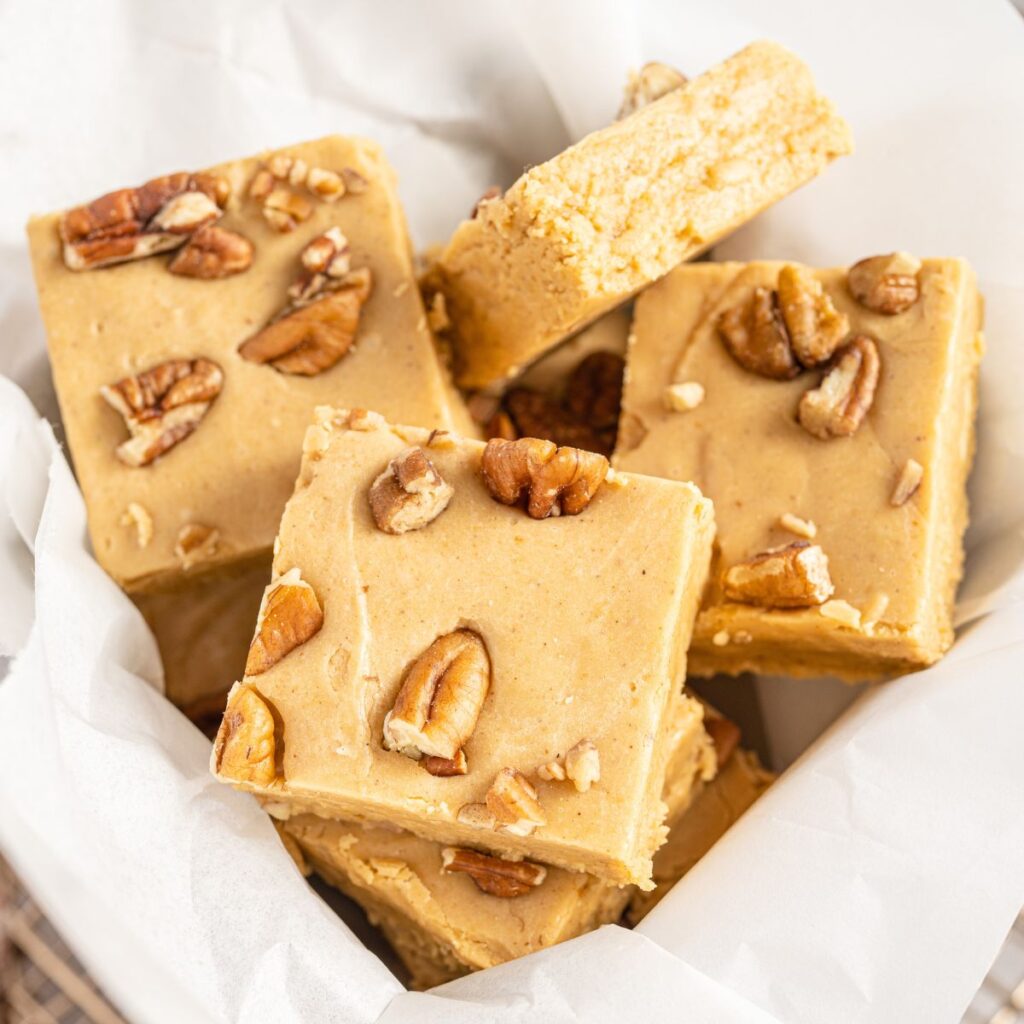 A white basket of fudge with pecans. 