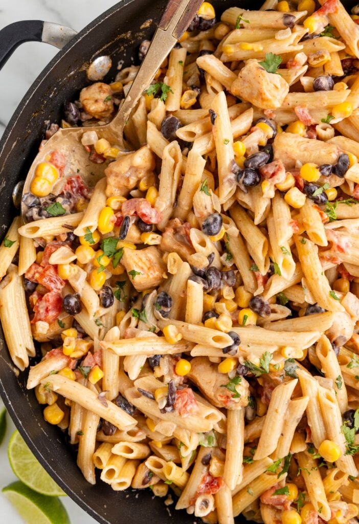 A skillet pan of penne pasta with southwest ingredients. 