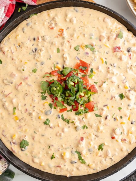 A cast iron skillet pan with velveeta cheese dip in it.