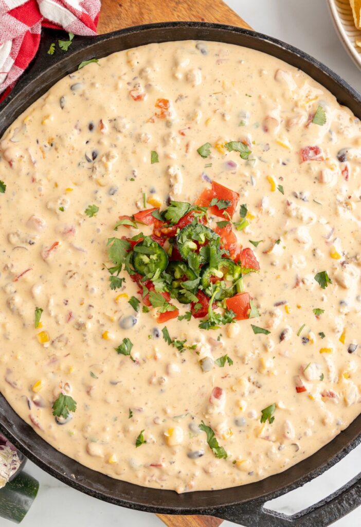 A cast iron skillet pan with velveeta cheese dip in it. 
