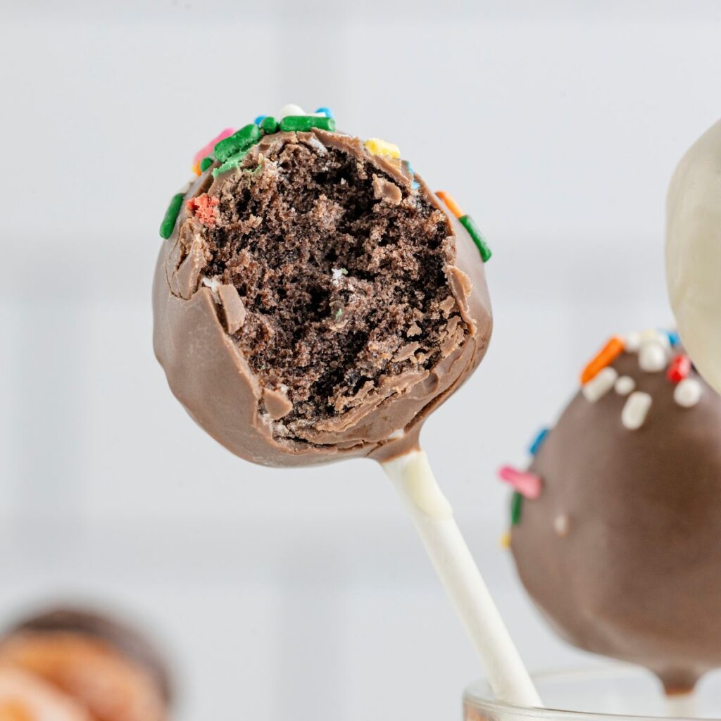 A cake pop with a bite taken out of it. 