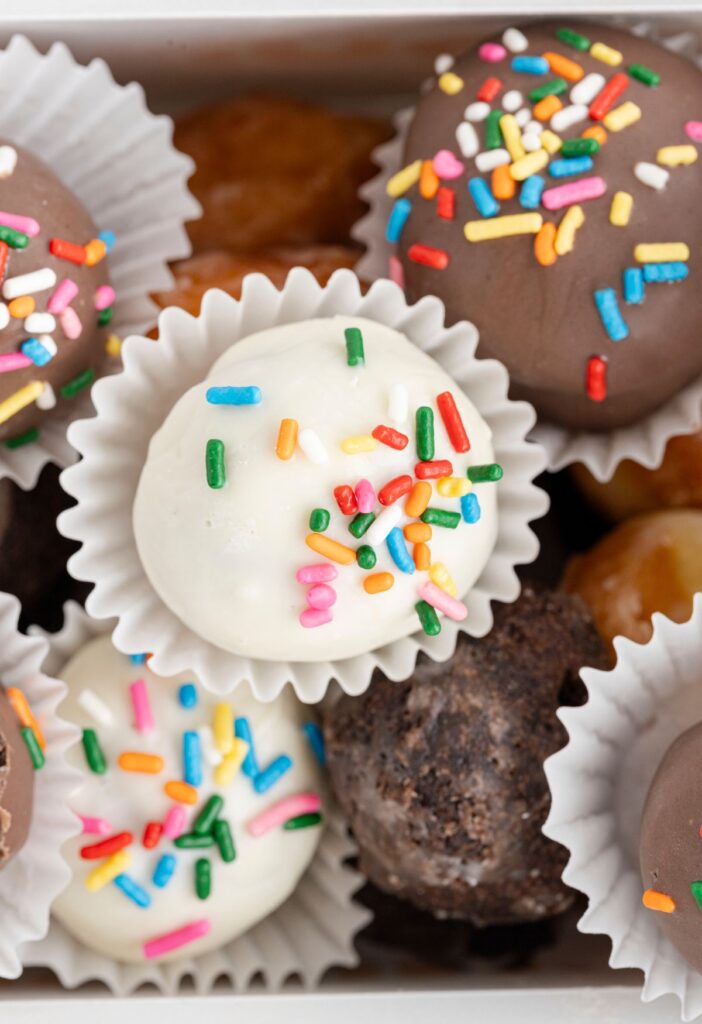 Pile of chocolate dipped donuts with sprinkles.