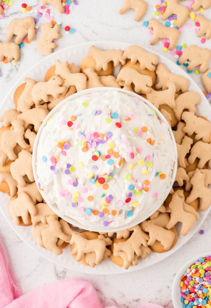Overhead picture of the dip with sprinkles on it and crackers around it. 