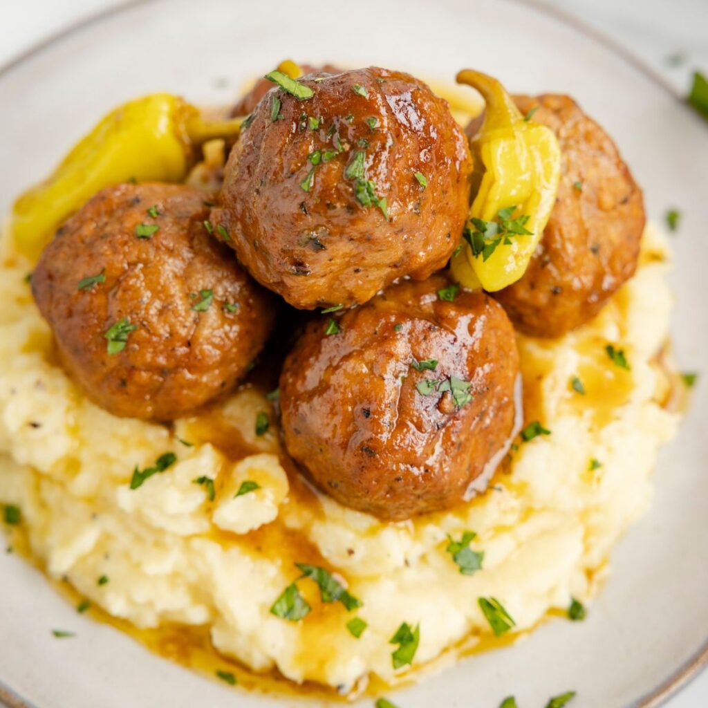 Cooked meatballs on a plate with mashed potatoes. 