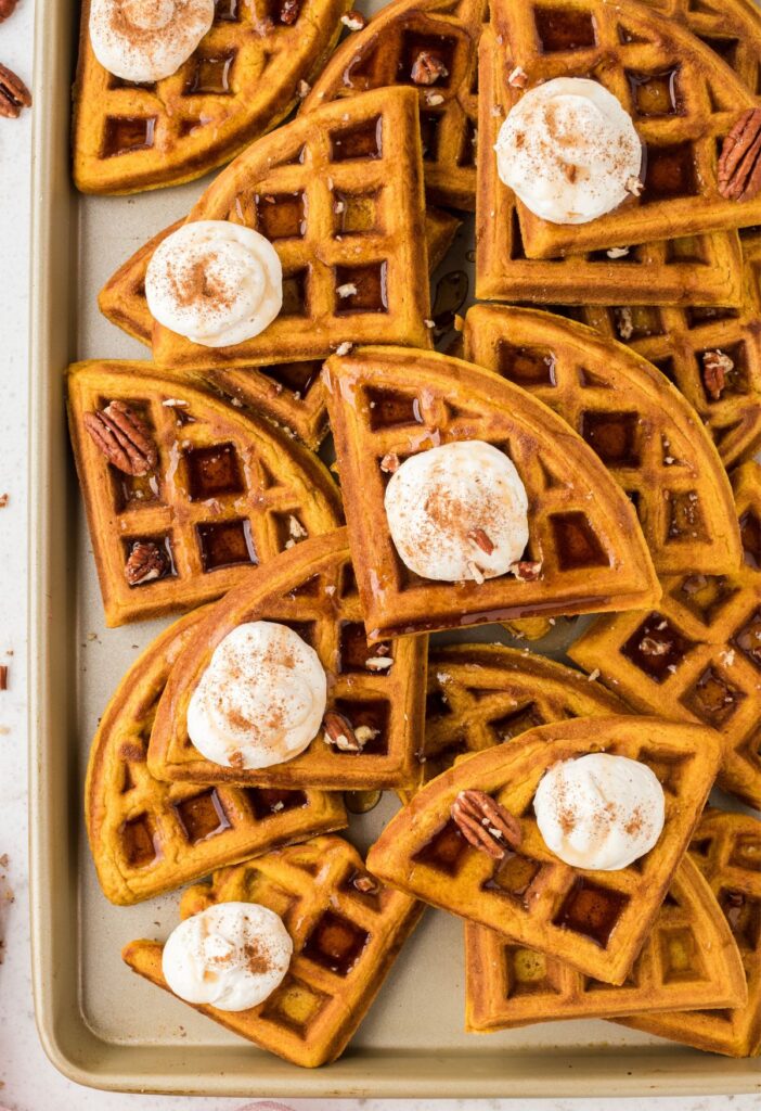 Waffle triangles on a baking sheet with whipped cream