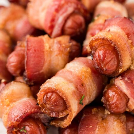 A pile of little sausages wrapped in bacon pieces.