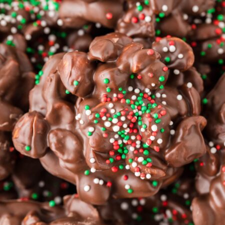 A close up of a peanut and chocolate cluster with sprinkles.
