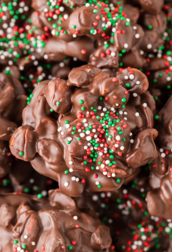 A close up of a peanut and chocolate cluster with sprinkles. 