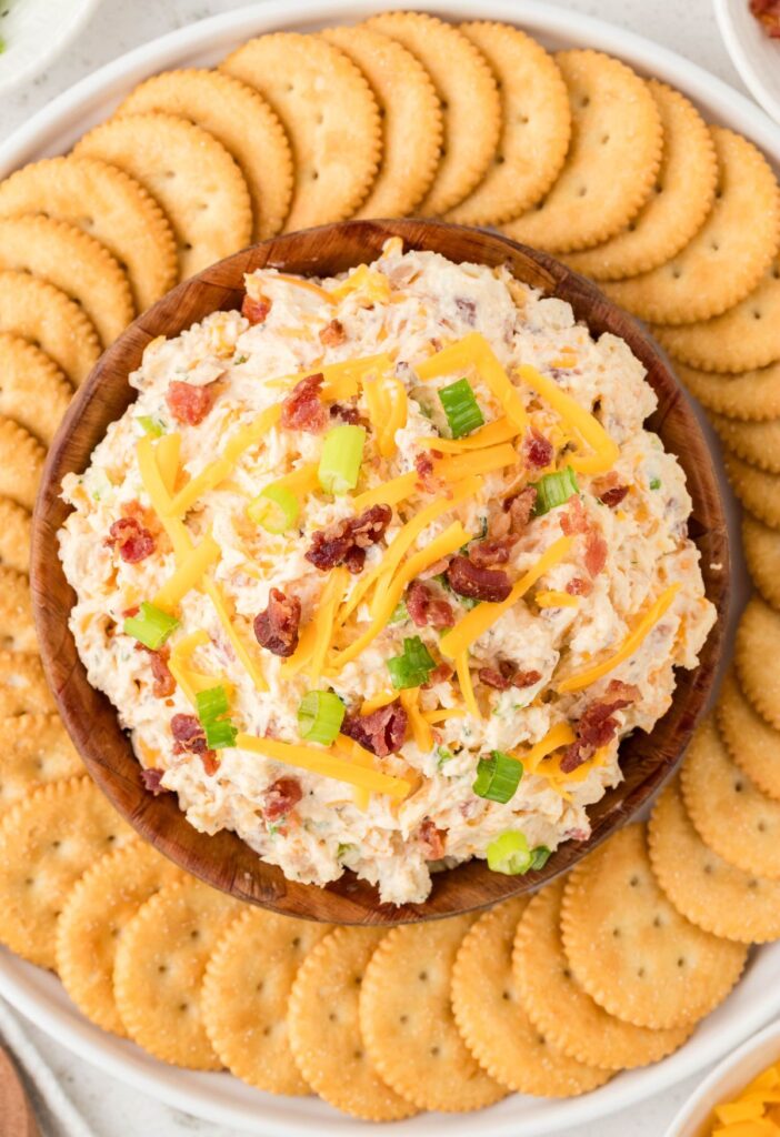 A plate of crackers and dip inside a bowl. 