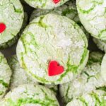 Stack of green cookies with a red heart sprinkle.