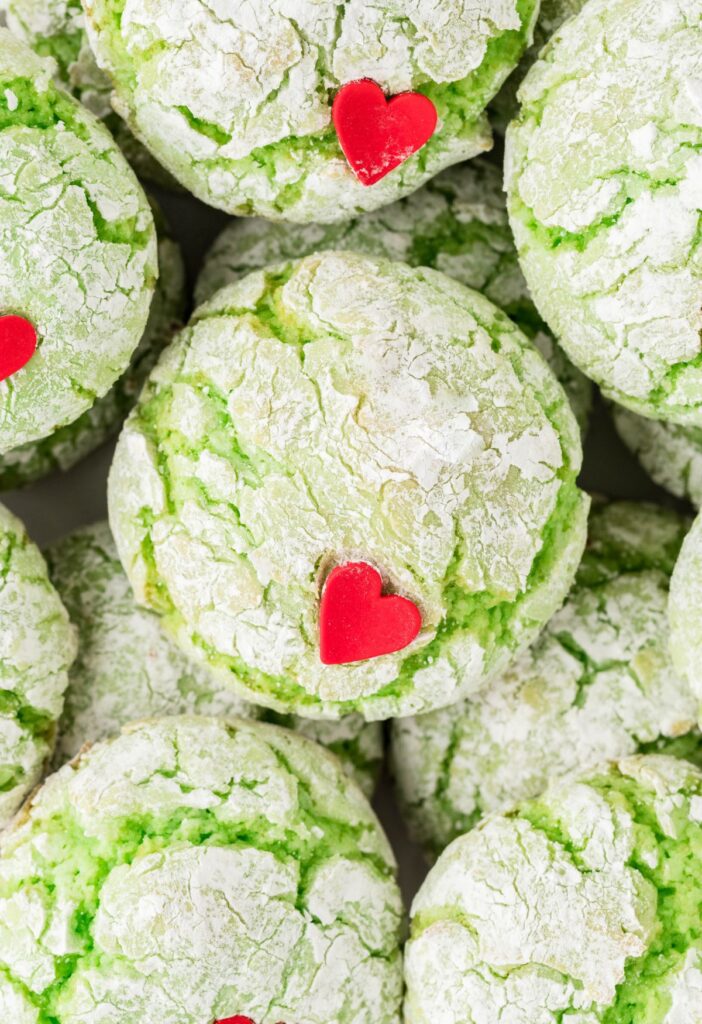 Stack of green cookies with a red heart sprinkle. 