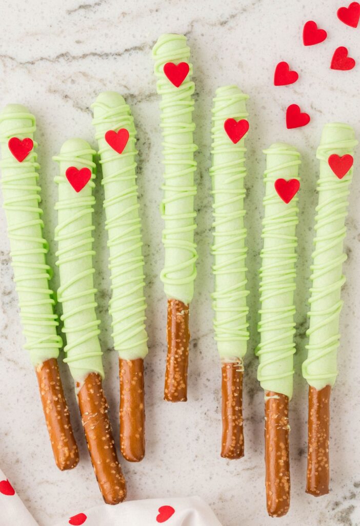 Pretzel rods dipped in green chocolate for a grinch themed treat. 
