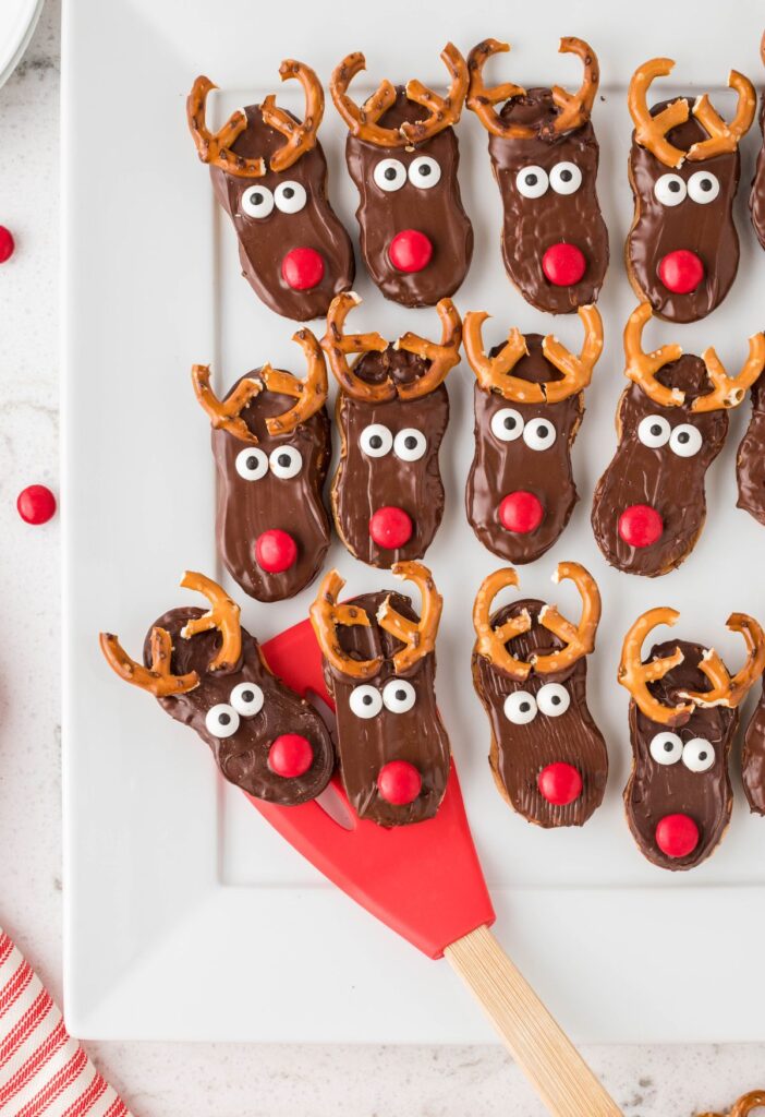 Overhead of the reindeer cookies with a red spatula. 