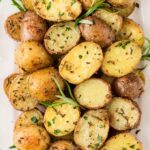 Serving dish of roasted potatoes with rosemary.