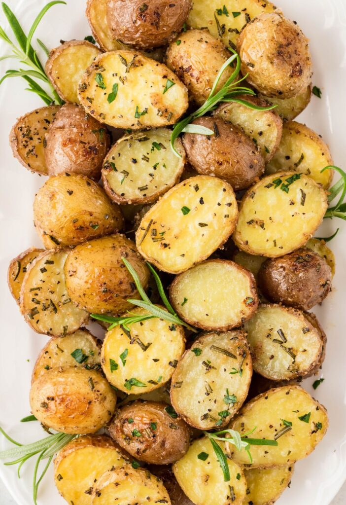 Serving dish of roasted potatoes with rosemary. 