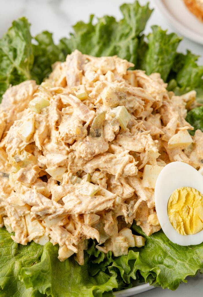 Chicken salad recipe on green lettuce and a hard boiled eggs. 