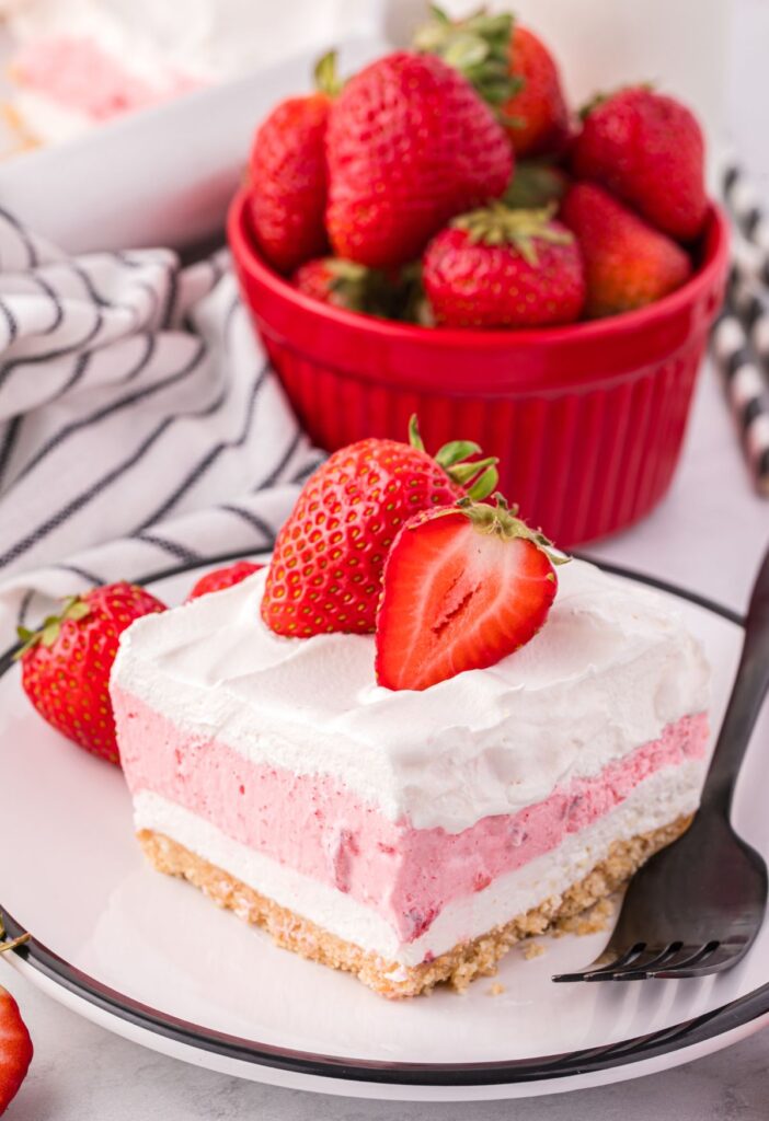 A slice of dessert with strawberries on top