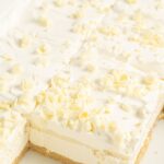 A layered lasagna dessert with white chocolate curls on top.