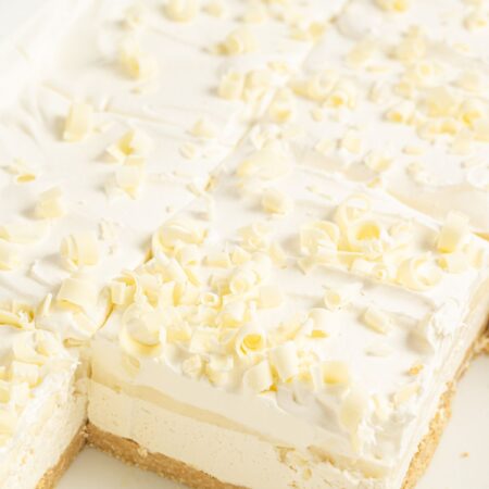 A layered lasagna dessert with white chocolate curls on top.